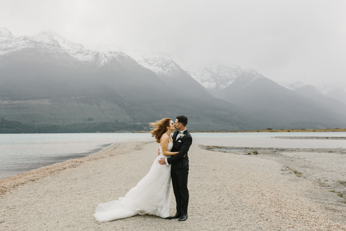 Bride and Groom kissing on the wild shores of Lake Wakatipu for their Glenorchy Elopement