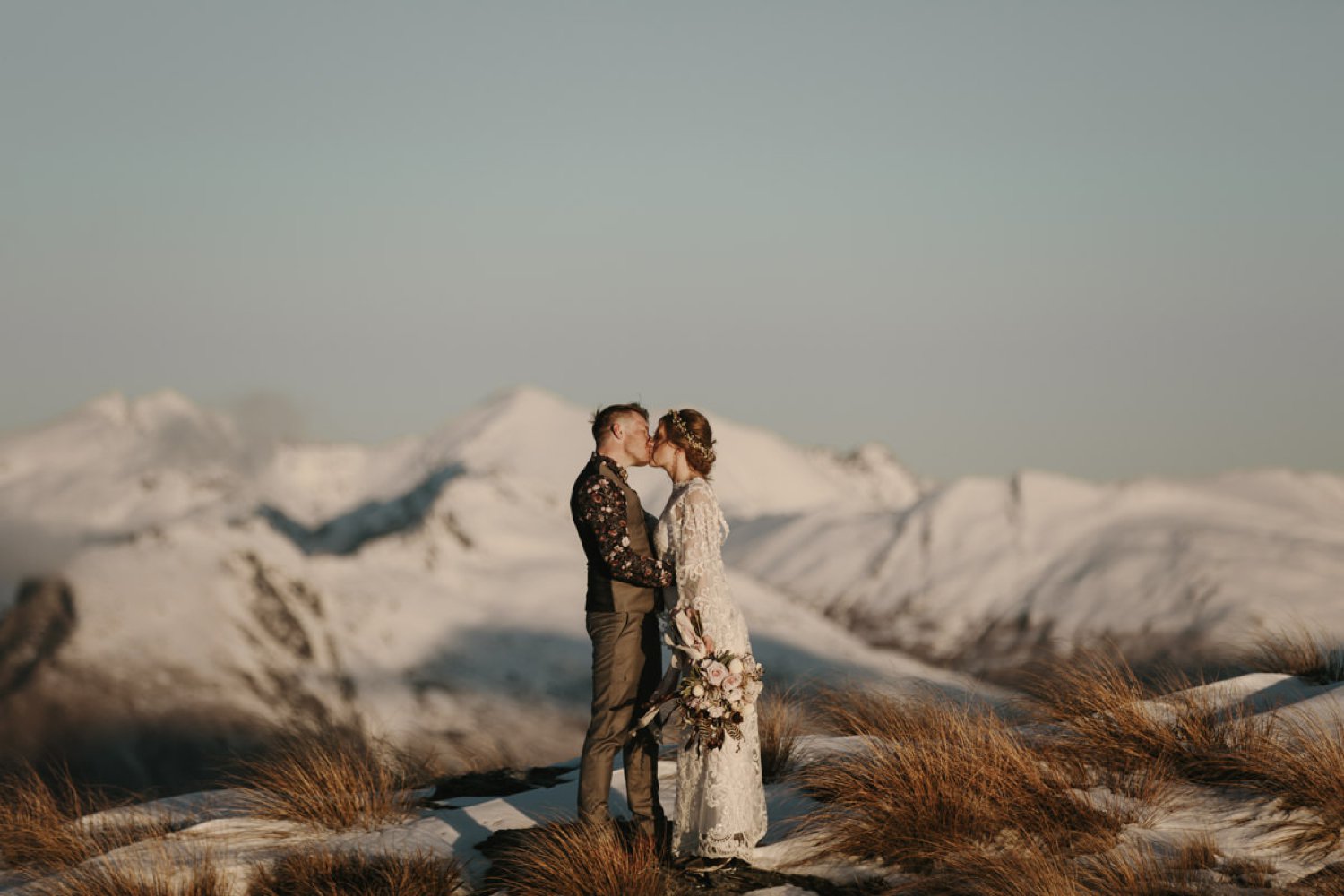 Bride and Groom kissing in the snow at their Cecil Peak Winter Helicopter Elopement by The Lovers Elopement Co
