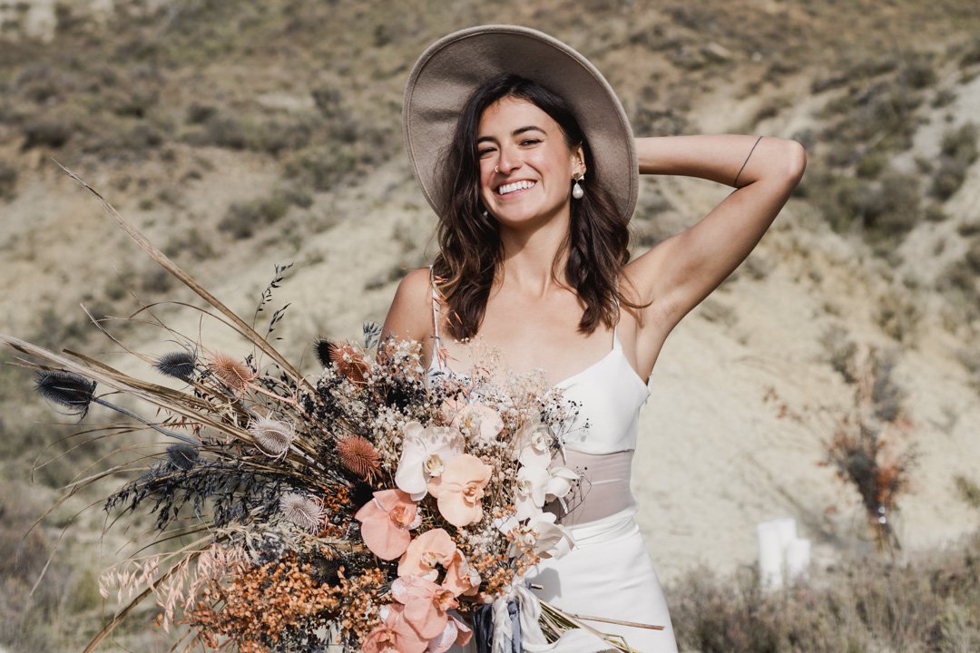Wild wedding bouquet with dusky pink and earthy tones at stylish Queenstown wedding and bride wearing L'eto Bridal Gown