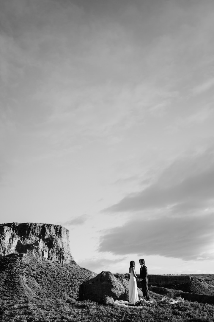 Bride and groom standing at sunrise at mountain elopement in Queenstown New Zealand by The Lovers Elopement Co