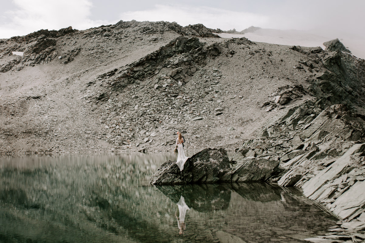 Bride and Groom at their New Zealand Elopement wedding standing on a glacier and mountain setting